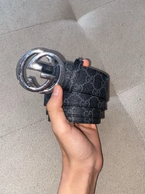 Svart grå bälte med silverspänne  - Svart grå bälte med silverspänna och är i bra skick