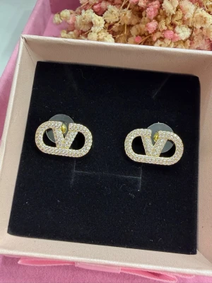 Eleganta örhängen  - Mycket vackra örhängen i rostfritt stål, pläterade med 18 karat guld. Dekorerade med gnistrande rhinestone-kristaller som ger ett exklusivt och elegant utseende. Allergivänliga och skonsamma mot huden – perfekta även för känsliga öron.  ✔ Rostfritt stål ✔ 18K guldplätering ✔ Allergivänliga ✔ Hållbara och behåller sin glans  💛 Stilrena örhängen som passar både till vardag och fest.