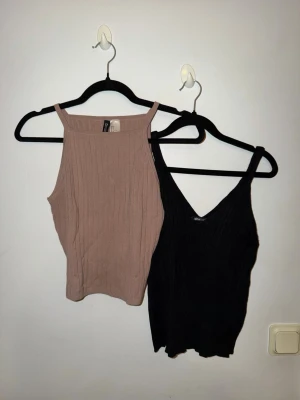 2 ribbade linnetoppar Gina Tricot & H&M - Säljer två ribbade linnetoppar, en svart från Gina Tricot i storlek S med v-ringning och en beige från H&M Divided i storlek M med högre hals. Båda är ärmlösa och har smala axelband. Perfekta att styla till jeans eller kjol.