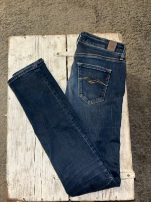Replay Hyperflex jeans blå - Säljer ett par blå Replay Hyperflex jeans i midwaist-modell. Jeansen har klassisk femficksdesign, snygga slitningar och kontrastsömmar. Materialet är stretchigt jeans för extra bekväm passform. Perfekta till sneakers eller boots.