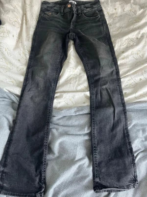 Mörkgrå lågmidjade bootcut jeans - Ett par snygga lågmidjade bootcut jeans från Gina tricot med fint broderade bakfickor.