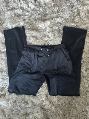 Blå Juicy Couture mjukisbyxor i velour  - Snygga blå Juicy Couture-byxor i mjuk velour. Klassisk Juicy-design med fickor bak och dragsko i midjan. Superbekväma och perfekta för både chill och outfit med Y2K-stil.  ✨ Bra skick ✨ Mjuk & skön velour ✨ Original Juicy Couture ✨ Storlek: 14/15 men som XS/S (se bilder på tag)  Säljs pga används inte längre. Hör av dig vid frågor eller om du vill ha fler bilder 💌
