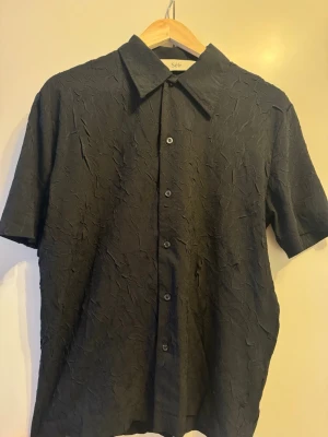 Skjorta med textur från Séfr - Svart skjorta med textur från Séfr. Perfekt till sommaren. Nypris 2500