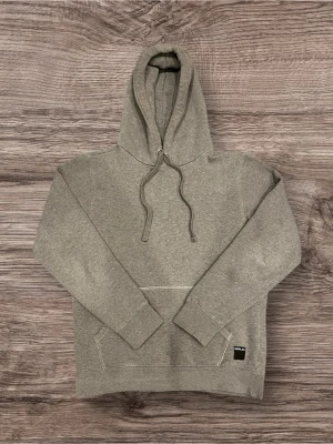 Replay hoodie / huvtröja – grå - Stilren grå hoodie från Replay. Klassisk modell med huva och justerbara dragsnören. Mjuk och bekväm kvalitet med borstad insida, perfekt för vardagsbruk. Liten Replay-logga nederst framtill som ger ett diskret och snyggt intryck. OBS! Står M i tröjan med passar S bättre. Mellan 170-180. 