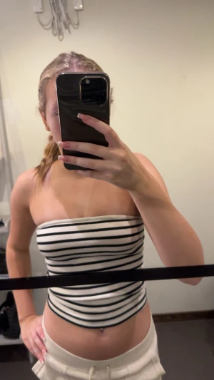 Randig bandeau tubtopp Gina Tricot - Säljer en snygg bandeau tubtopp från Gina Tricot i storlek S. Toppen är vit med svarta horisontella ränder och har en tight passform. Perfekt till sommaren och enkel att matcha med shorts eller kjol.