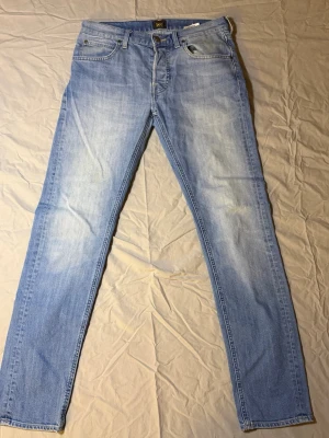 Lee Jeans Ljusblå – W30 L32 – Mycket bra skick - Säljer ett par Lee jeans i ljusblå färg, storlek W30 L32, i mycket bra skick. Fräsch färg och klassisk look som passar perfekt till vår, sommar och höst.  Snygg passform och lätt att matcha med t-shirt, hoodie eller skjorta.  • Märke: Lee • Färg: Ljusblå • Storlek: W30 L32 • Skick: Mycket bra skick • 100 % original  Skickas snabbt efter köp. Hör av dig vid frågor.  Lee 3
