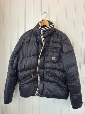 Svart Moncler pufferjacka med detaljer - Viktige Moncler dunjacka utan luva.