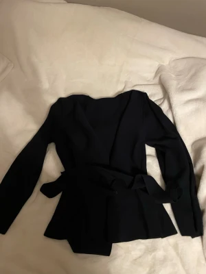 Mörkblå knyt kofta  - Säljer denna mörkblåa kofta som man knyter med banden runt om. Jätte skönt material och snygg. Passar till nästan allt. Aldrig använd 