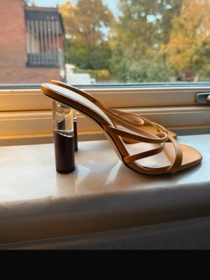 Gula sandaler med transparent klack från Zara - Säljer ett par trendiga gula sandaler från Zara med smala remmar och fyrkantig tå. Klacken är unik med transparent detalj och svart bas. Snygg design som sticker ut och passar perfekt till sommarens outfits.💛