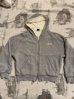 Corteiz HMP Zip Up Hoodie Grå - Säljer min Corteiz HMP Zip Up Hoodie – en riktigt tung och kvalitativ hoodie som väger över 1 kg, perfekt för kalla dagar och vintern. Modellen har dubbel dragkedja, vilket gör den både snygg och praktisk att styla på olika sätt.  Hoodien är i fint skick och väldigt lite använd. Det finns en pytteliten fläck som är så diskret att man knappt märker den, men jag nämner det för transparensens skull.  Passar dig som vill ha en hoodie med premiumkänsla, tyngd och riktigt bra värme. borttappat kvitto
