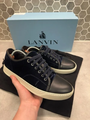 Lanvin skor - Tjena! Säljer nu ett par feta Lanvins i mörkblå sammet med svart matt tå || Skorna medföljer box och dustbags|| snörena som är på skorna nu är inte originella men två originella snören kommer med i boxen|| skicket är bra finns en del defekter som syns på sista bilderna|| Obs fler liknande defekter kan finnas på skorna|| Storlek 42|| hör av dig vid frågor🙌//StenhamCloset