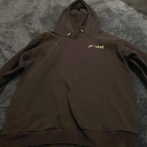 Svart hoodie Ma Chérie Gina Tricot - Svart hoodie från Gina Tricot med texten 'Ma Chérie' broderad i vitt på bröstet. Klassisk modell med huva och snörning, tillverkad i mjuk bomull. Perfekt för chill dagar eller när du vill ha en enkel men snygg look.