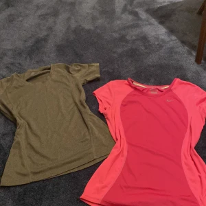 Nike Dri-Fit rosa tränings-tshirt S - Nike Dri-Fit t-shirt i stark rosa med ljusare rosa paneler. Perfekt för träning, snabbtorkande och andasmaterial. Klassisk Nike-logga på bröstet och sportig passform. Kortärmad och tillverkad i polyester för maximal komfort. Andra kommer på köpet 😌