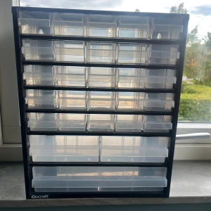 Cocraft Förvaringsskåp med Lådor - Praktiskt förvaringsskåp från Cocraft med många små lådor, perfekt för elektronikkomponenter eller smådelar. Skåpet är i mycket gott skick utan synliga skador eller slitage. Transparenta lådor gör det enkelt att organisera och hitta dina saker.