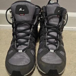 Gråa Viking Gore-Tex kängor - Säljer ett par gråa kängor från Viking med Gore-Tex membran. Skorna har svart snörning, robust sula med bra grepp och detaljer i syntet och textil. Perfekta för utomhusaktiviteter och äventyr. Märket syns tydligt på sulan och sidan.