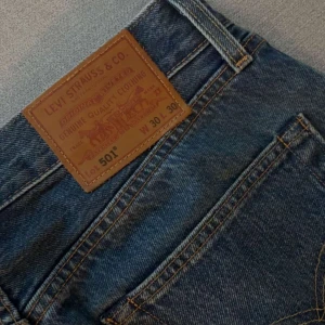 Levi's 501 blå jeans - Klassiska Levi's 501 jeans i blå denim med raka ben och normal passform. Snygga kontrastsömmar och ikonisk läderpatch bak i midjan. Perfekta för dig som gillar tidlös stil och vill ha ett par jeans som funkar till allt. W 30 L 30| pris går att diskuteras