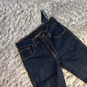 Nudie Slim Jim - Säljer dessa riktigt snygga Nudie jeansen i modellen Slim Jim som har en slim passform. De är i bra skick utan defekter och är i storlek 27/34. Bara att skriva över frågor och funderingar.