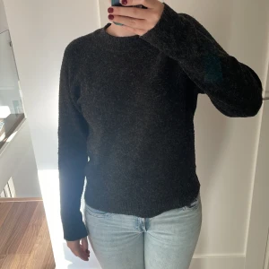 Svart stickad tröja från VERO MODA - Säljer en stickad tröja från VERO MODA. Casual design och sticks inte. Den är svart med lite grå detaljer i hela tröjan. Använts några gånger men syns inga tecken av slitage.