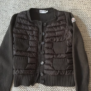 Jacka/kofta från Moncler (gamla modellen) - Superfin brun / svart Moncler jacka. Har inga skador och är i ett väldigt bra skick!! Har använt ett par gånger men har inte hittat användning av den. Det är därför jag väljer att sälja den. Kan också tänka mig att byta om ni har någon jacka i samma märke i en annan modell! 🥰