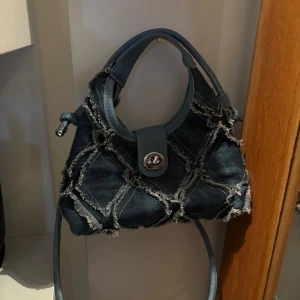 Väska med jeans tyg  - Jätte cool väska med jeans tyg. Den har ett längre band och vanligt Väsk handtag. Andvänt 1 gång. Jätte cool med jeans och perfekt till sommaren 