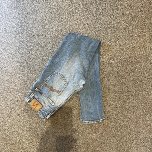 Nudie Skinny Lin jeans i storlek W29/L30 - Nudie Skinny Lin jeans i storlek W29/L30. Mörkblå denim med slim fit-passform och stretch som gör dem bekväma. Bra skick utan hål eller fläckar, bara lite slitningar. Nypris runt 1500–2000 kr.  Mått: A (midja): 36 cm B (lårvidd): 24 cm C (fotvidd): 14 cm D (innerbenslängd): 74 cm  Säljes för 299 kr. 