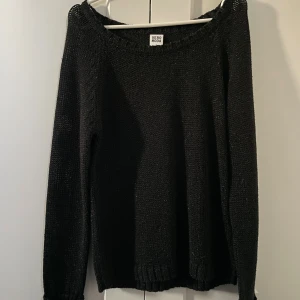 Svart stickad tröja från Vero Moda - En svart stickad tröja från Vero Moda med rund halsringning och långa ärmar. Den är glittrig men det ligger mer i tyget och ramlar inte av!