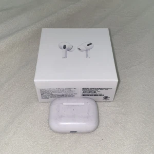 AirPods Pro med MagSafe-laddningsetui - Apple AirPods Pro med MagSafe-laddningsetui. Aktiv brusreducering, transparensläge och trådlös laddning. Hörlurarna och etuiet har synligt slitage och repor, men fungerar. Originalförpackning medföljer. Perfekt för dig som vill ha premiumljud till ett bra pris.