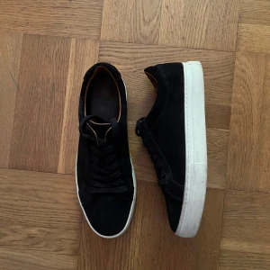 Svarta mockasneakers från Vagabond - Snygga svarta sneakers från Vagabond i mocka med vit platt sula och klassisk snörning. Skorna har en stilren och minimalistisk design med rund tå och diskreta detaljer. Nypris 1300 kr. Kan gå ner i pris vid snabb affär med Instabox leverans!🚚 