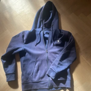 Marinblå hoodie från Polo Ralph Lauren - Snygg marinblå hoodie från Polo Ralph Lauren. Använd men fortfarande i väldigt gott skick, 