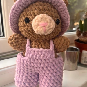  virkad nalle med overaller  - Supergulliga virkad nalle. Byxorna är fluffiga och har en loose passform med breda ben. De är virkade i ett mjukt garn som känns mysigt och trendigt.