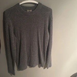 Grå stickad tröja från H&M - Grå stickad tröja från H&M i regular fit. Tröjan har rund halsringning och långa ärmar. Storlek S. Nypris: 500kr