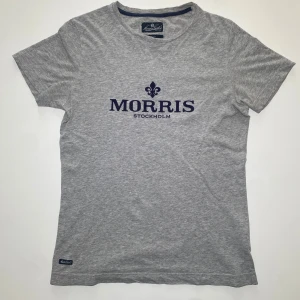 Grå t-shirt från Morris Stockholm -  Mycket liten fläck längst nere på ryggen(se sista bilden) särav priset. Jag säljer den eftersom den blivit för liten. Inga andra fel eller defekter. Hör av er för frågor eller pris diskutering