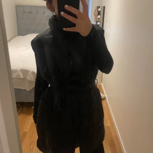 Svart Väst - Svart väst som är lite oversized men knyts runt midjan, använt ca 2 gånger.