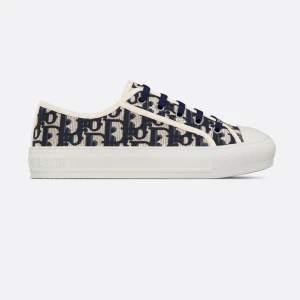 Dior Oblique sneakers i blått och vitt - Snygga Dior Oblique sneakers med blått och vitt monogrammönster, rund tå och platt sula. Skorna har snörning och är tillverkade i canvas med vita detaljer och gummisula. Perfekt för dig som vill ha en lyxig och trendig look.