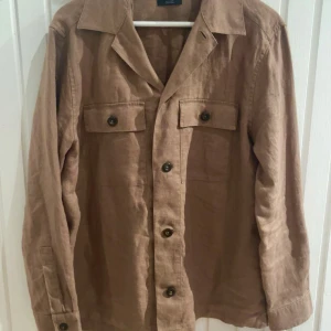 Brun overshirt i linne från Massimo Dutti - Säljer en brun overshirt från Massimo Dutti i 100% linne. Använd en gång så helt i nyskick! Säljer pga fel storlek!