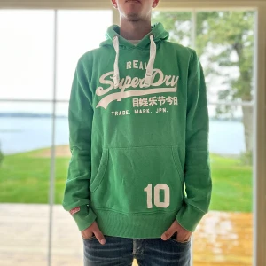 Superdry Hoodie - Grön Superdry hoodie i mycket bra skick | Storlek: M | Jag är 182cm och väger 65kg📏| Vid frågor eller diskussion om pris är det bara att skriva ✍🏼 | Frakt inom 48h📦