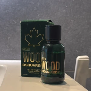 DSQUARED2 Green Wood EdT 50ml - Fräsch och maskulin parfym från DSQUARED2, Green Wood. Flaskan är grön med svart kork och guldiga detaljer. Kommer i originalkartong med ikoniskt lönnlövs-motiv. Eau de toilette för honom, 50 ml. Perfekt för dig som gillar träiga och fräscha dofter.