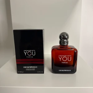 Emporio Armani Stronger With You Parfum - Emporio Armani Stronger With You Parfum i en elegant mörkröd glasflaska med rundad silverkork. Doften är maskulin och modern, perfekt för dig som vill sticka ut. Flaskan rymmer 100 ml och kommer med originalkartong.