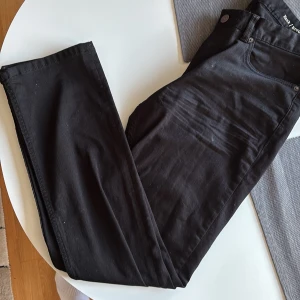 Svarta Hank Regular Fit jeans W32 L32 - Svarta jeans från Hank i regular fit med klassisk femficksdesign. Byxorna har rak passform och är tillverkade i ett mjukt bomullstyg med lite stretch. Perfekta för dig som gillar en clean och stilren look. Hör av er vid fler bilder, pris kan diskuteras!