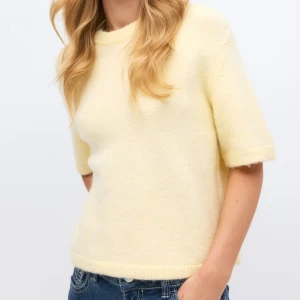 Ljusgul stickad tröja  - Ljusgul stickad tröja från Gina med kort ärm och rund halsringning. Endast använd ett fåtal gånger 