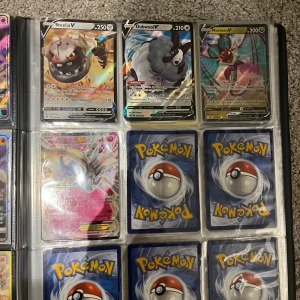 Pokémon TCG: Samlaralbum med V, GX och VMAX-kort - Färgstarkt samlaralbum fyllt med exklusiva Pokémonkort som Steelix V, Lapras VMAX, Jolteon GX och fler. Perfekt för dig som älskar Pokémon och vill boosta din samling med coola, holografiska och sällsynta kort. En riktig skatt för både nya och erfarna samlare! Säljes som pack men kan säljas en och en isåfall kom med pris förslag