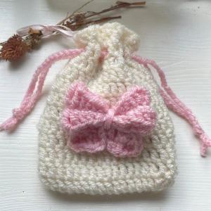 Virkad pouch - Virkad drawstring pouch med rosett och tyg inuti. Perfekt för AirPods eller att ha smycken i💕