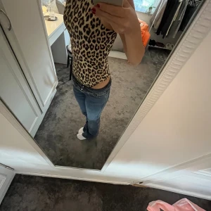 Leopardmönstrad ärmlös bodysuit H&M - Säljer en snygg leopardmönstrad bodysuit från H&M. Den är använd ändast ett fåtal gånger. Den är ärmlös med högt skuren hals och tryckknappar i grenen. Materialet är stretchigt och mjukt, perfekt för att skapa en cool och trendig look. Färgerna går i beige och svart.