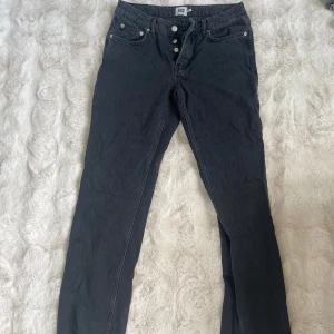 Svarta jeansbyxor med raka ben - Snygga svarta jeansbyxor från 157 med raka ben och klassisk femficksdesign. Byxorna har knäppning med tre synliga knappar framtill och är tillverkade i ett mjukt jeansmaterial. Perfekta för en chill och stilren look.