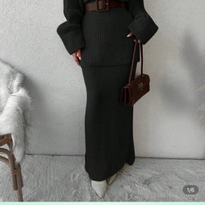 Svart stickad långärmad tröja med matchande kjol - Matcha stickad tröja och långkjol i samma färg för en harmonisk och trendig look. Tröjan har rund hals, lång ärm och loose passform med mjuk, grovstickad struktur som ger en cozy vibe. Kjolen har rak passform, bred resår i midjan och ribbstickning med chunky känsla – perfekt för höst och vinter. Tillsammans blir det en stilren, bekväm outfit som enkelt kan stylas med boots eller sneakers.