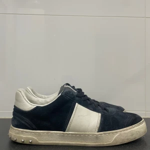 Valentino  Flycrew - Snygga sneakers från Valentino med mocka och skinnpaneler. Kommer med allt OG, box, skosnören osv. Köpt i Rom för 4/5 år sen. Har inte använt dem på flera år så man kan lätt göra dem fräschare. 2 nitar har gått bort. Stlr 41 passar 42.