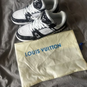 Louis Vuitton svartvita sneakers - Louis Vuitton sneakers i svart och vitt med klassiskt monogrammönster. Storlek 43 och väldigt bra skick.