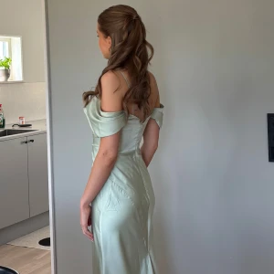 Ljusgrön långklänning med offshoulder - Säljer min fina ljusgrön balklänning. Endast använd en gång, dem har inga skador eller tecken på användning. Har sytt upp den lite samt sytt på axelband för att göra den mer bekväm. Är 166 och har klackar på bilderna. Nypris 1700kr från ASOS design 🫶🏼🫶🏼