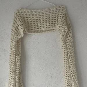 Vit stickad bolero från Romwe - Säljer en vit stickad bolero från Romwe i storlek S. Tröjan är virkad med grova maskor och har långärmad design. Perfekt att slänga över ett linne eller klänning för en cool lager-på-lager-look. Materialet är 100% akryl.