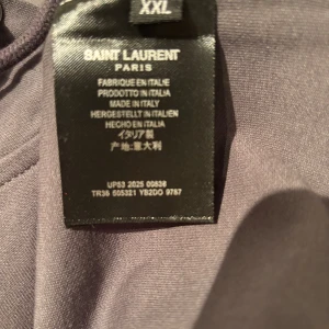 Grå Saint Laurent hoodie - Grå saint Laurent hoodie i storlek XXL, men passar dock XL perfekt! Vid fler funderingar slå ett pling. PRIS KAN DISKUTERAS. MÖJLIGTVIS BYTEN OCKSÅ!